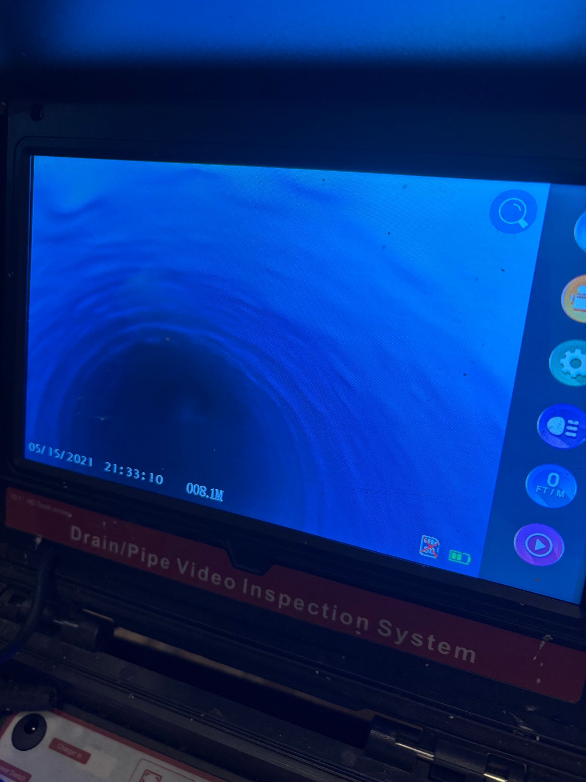 Écran affichant un vide circulaire sombre à l'intérieur d'un système d'inspection de tuyauterie teinté en bleu.