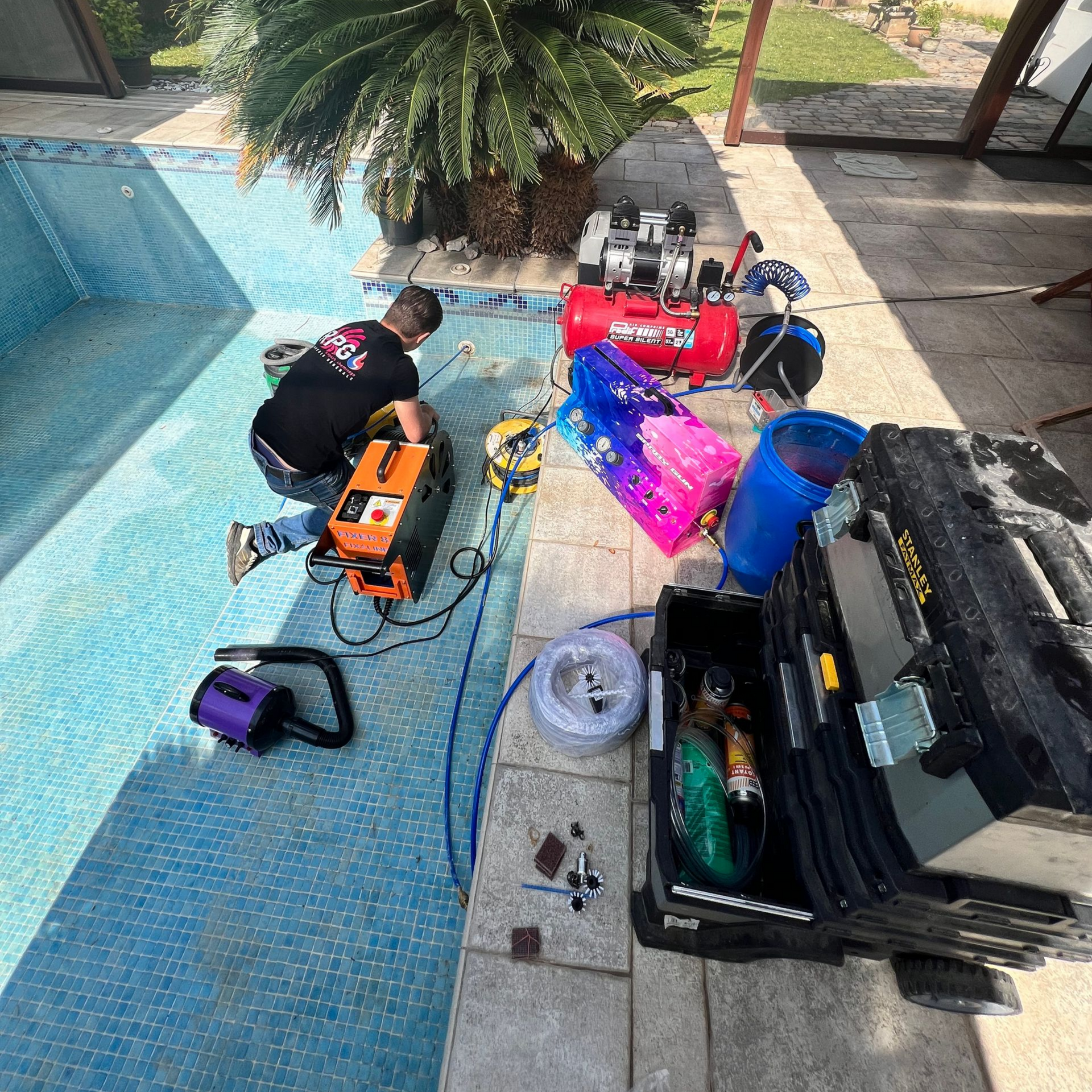 Personne près de la piscine avec des outils, en train de souder.