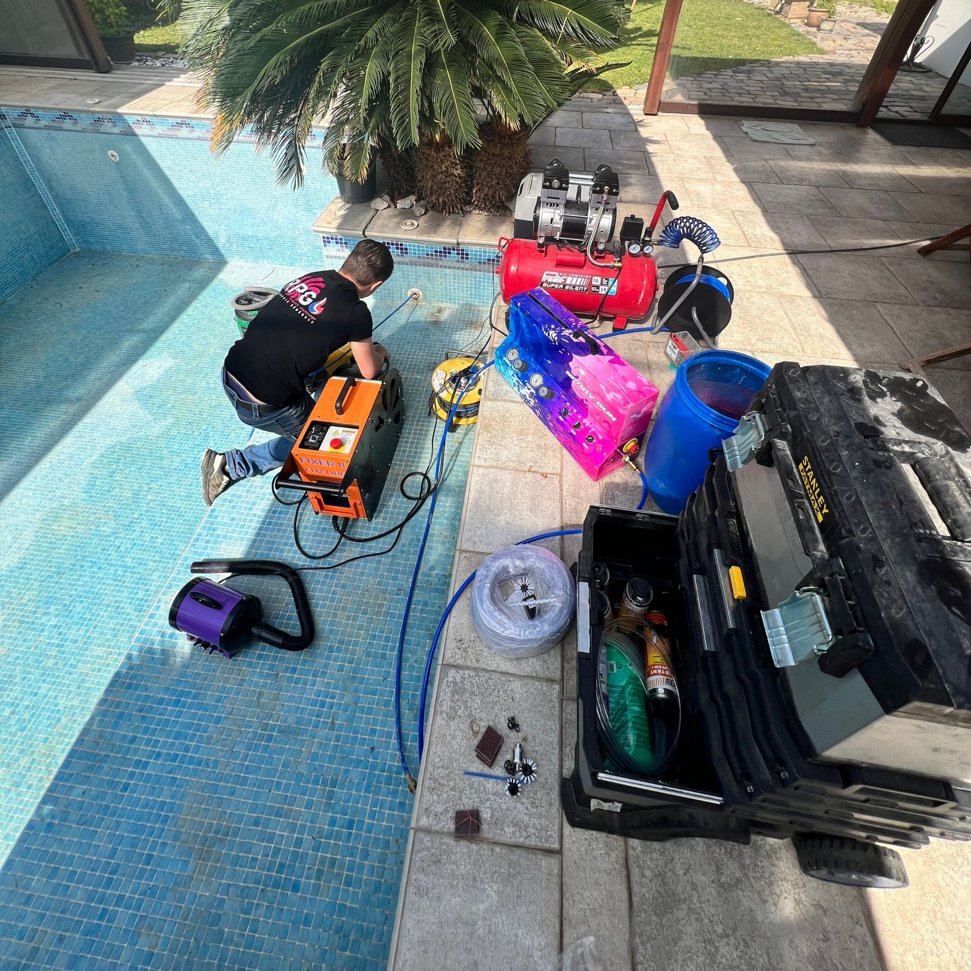 Deux personnes travaillent à l'entretien de la piscine près des équipements.