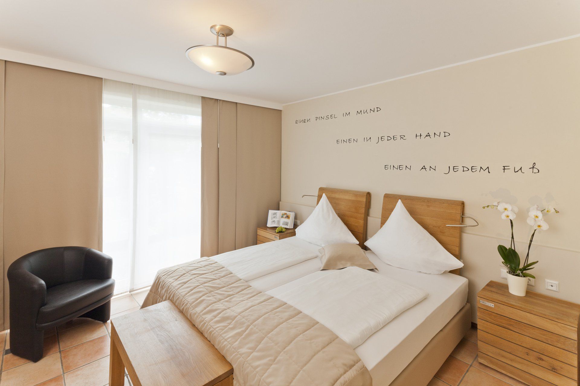 Ein Schlafzimmer mit zwei Betten und einem schwarzen Stuhl