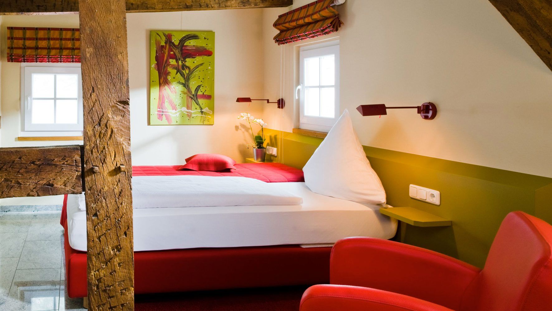 Ein Hotelzimmer mit zwei Betten und einem roten Stuhl