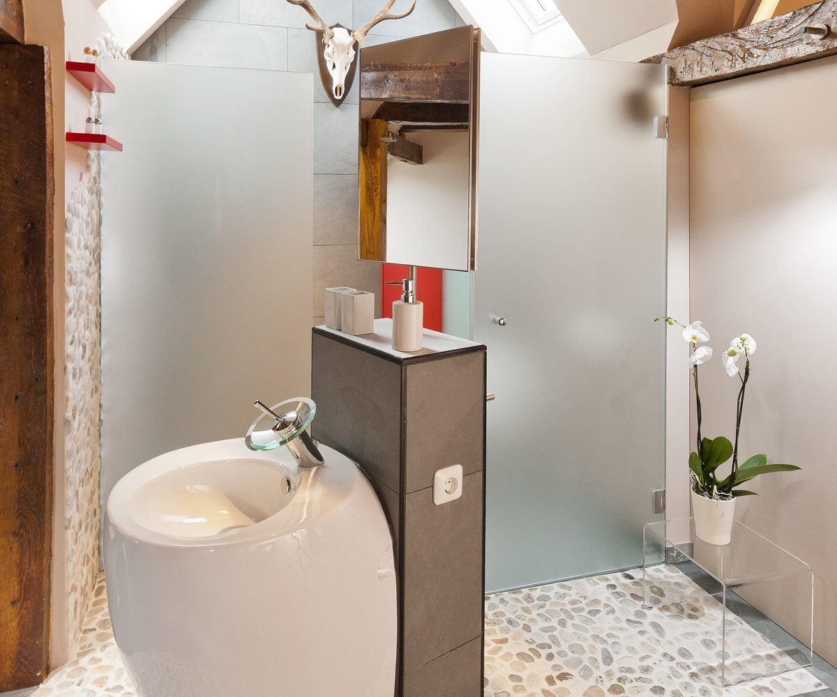Ein Badezimmer mit Waschbecken und Glasduschtür
