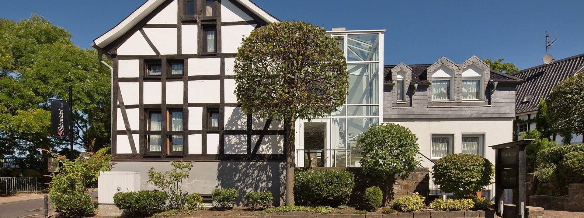 A black and white house with a glass elevator in front of it