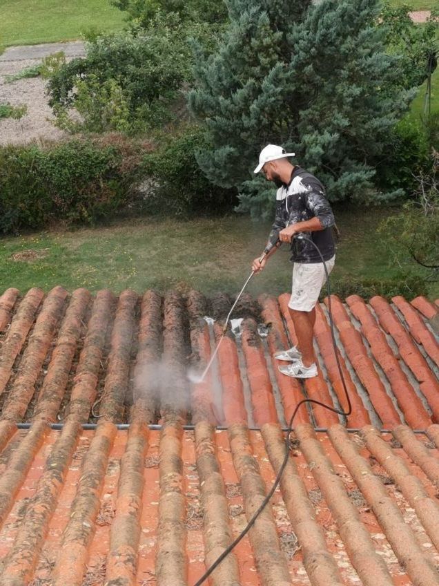 Un professionnel qui assure le nettoyage de la toiture