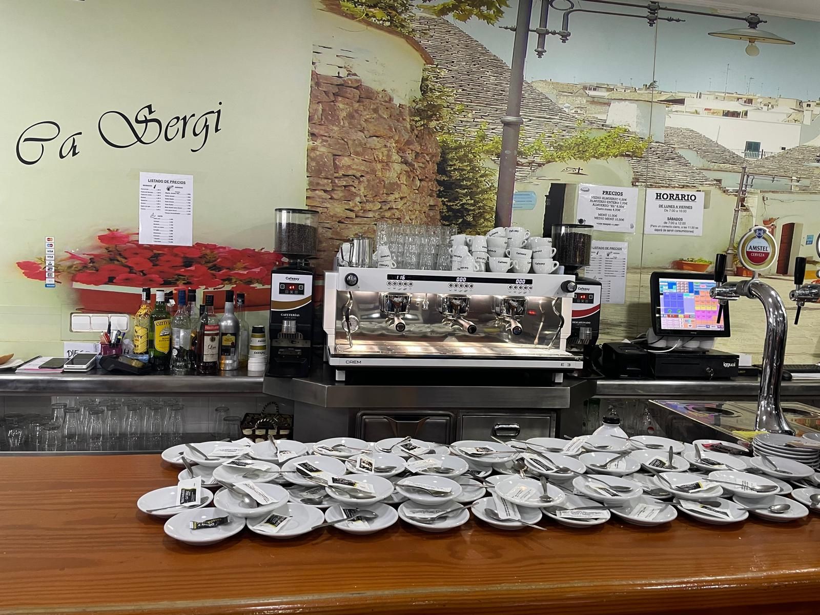 Un bar con muchos platos y una máquina de café.