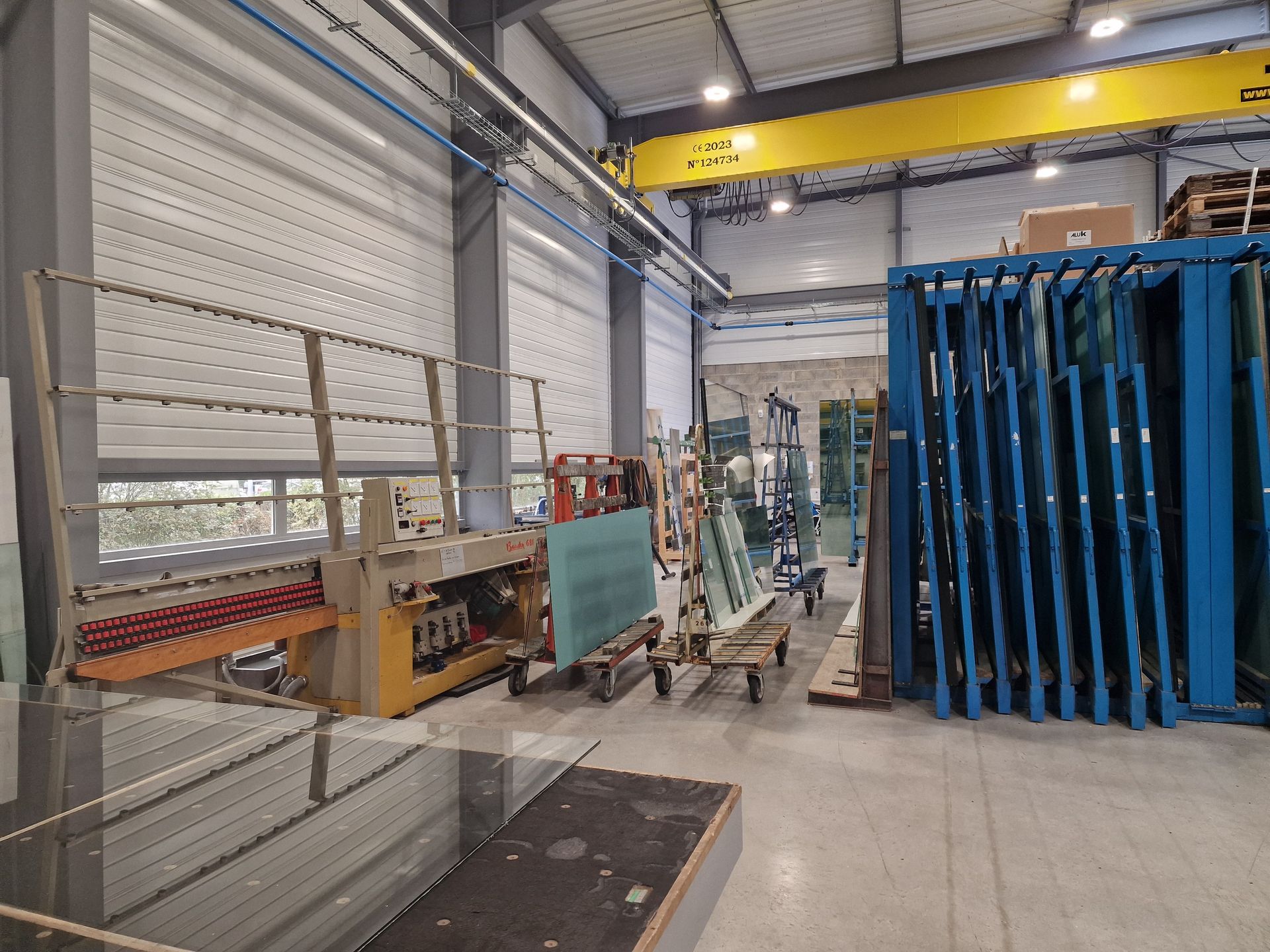 Intérieur d'un entrepôt avec vitres et pont roulant.