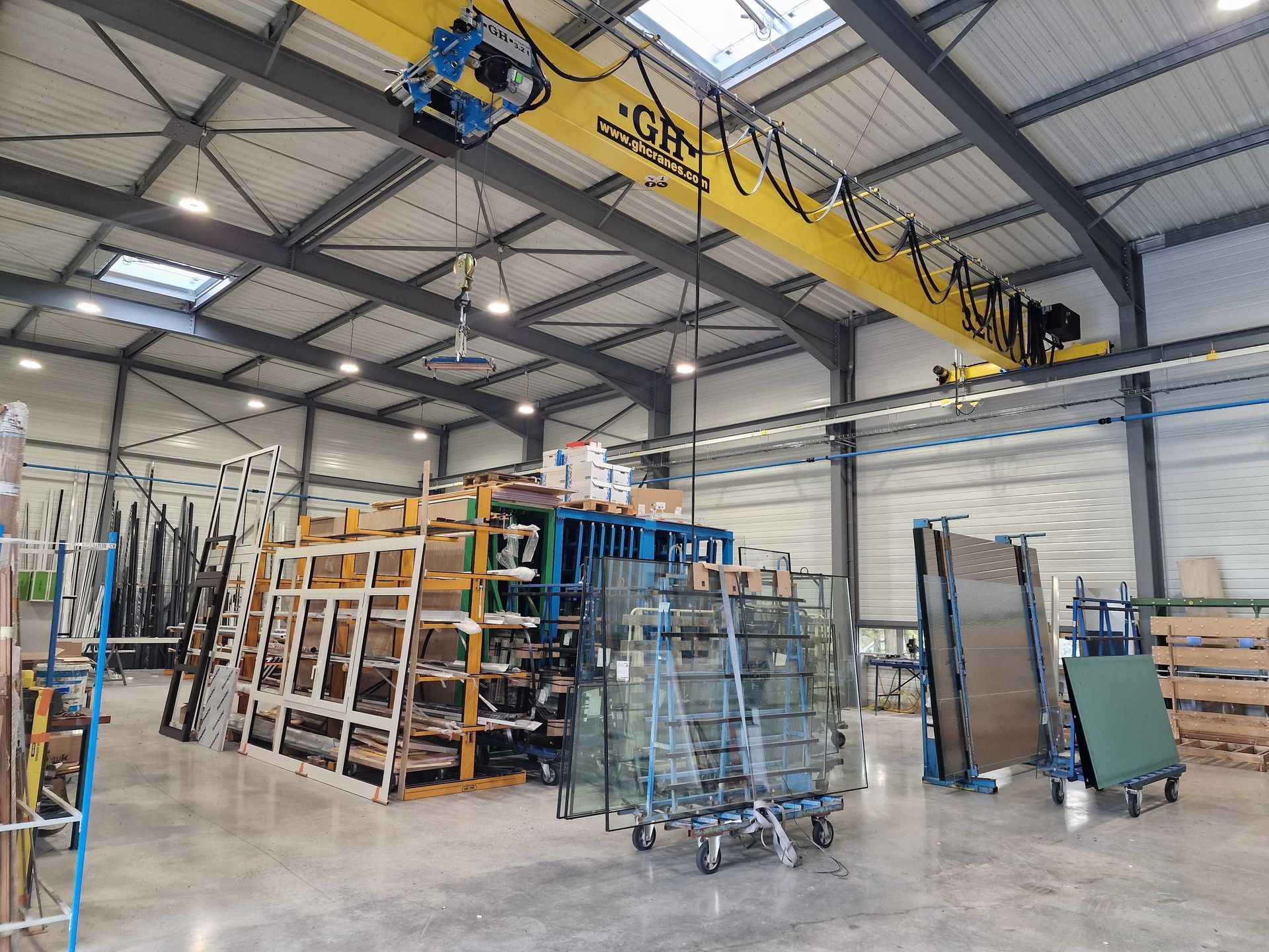 Intérieur d'entrepôt avec étagères vitrées, pont roulant et fenêtres.