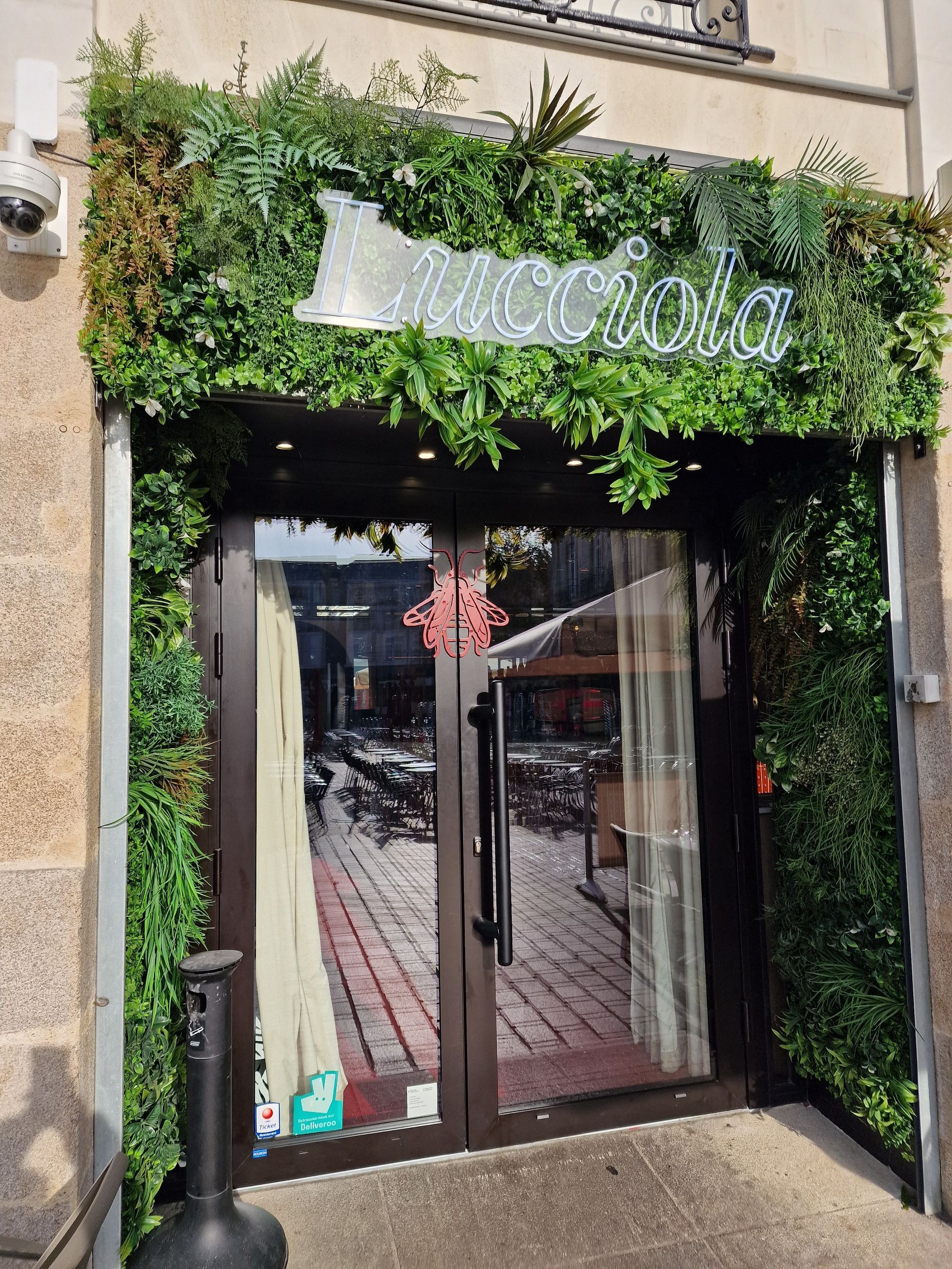 Entrée d'un bâtiment ornée de verdure.