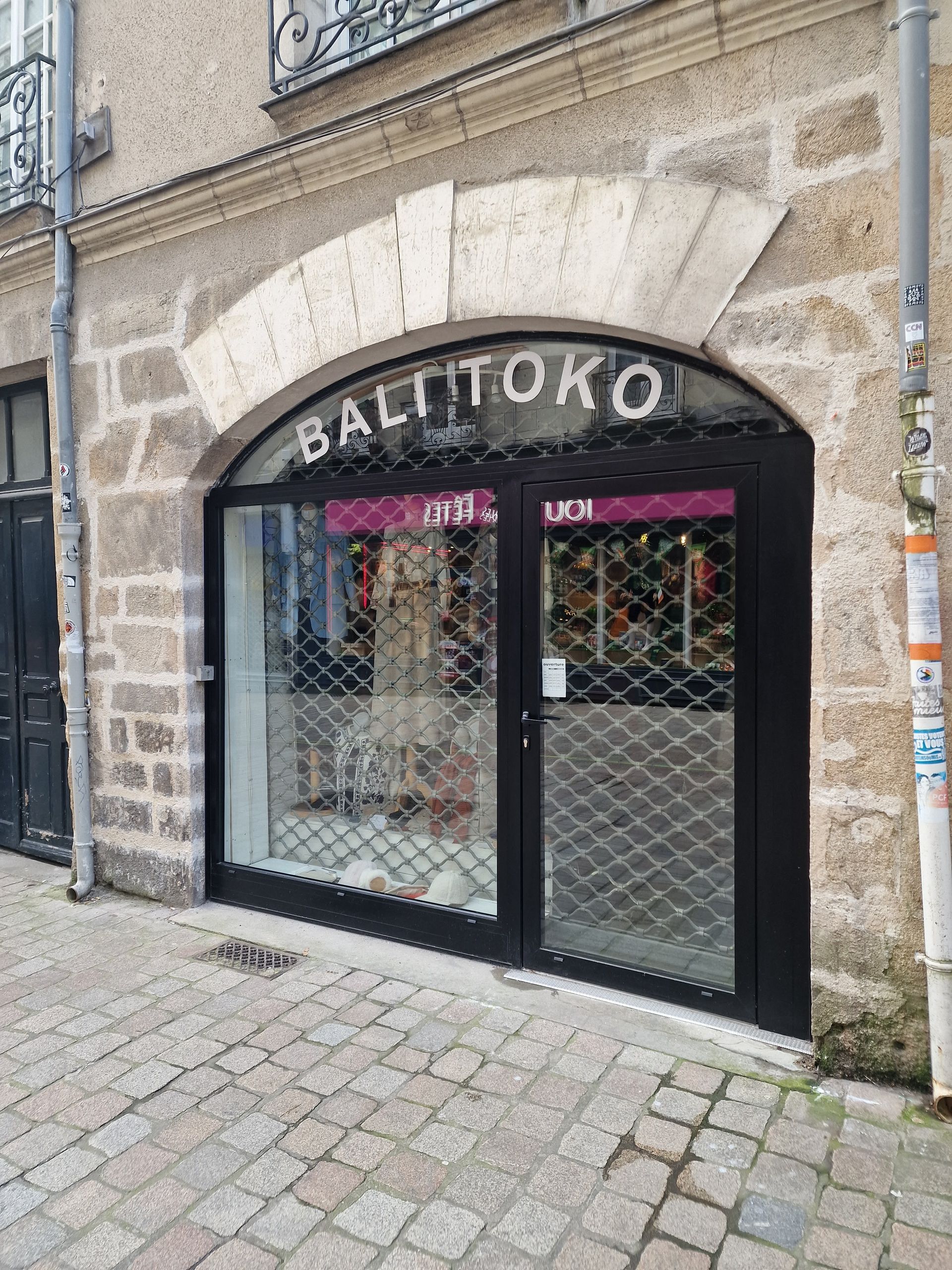 Façade avec des portes noires et un portail de sécurité métallique.