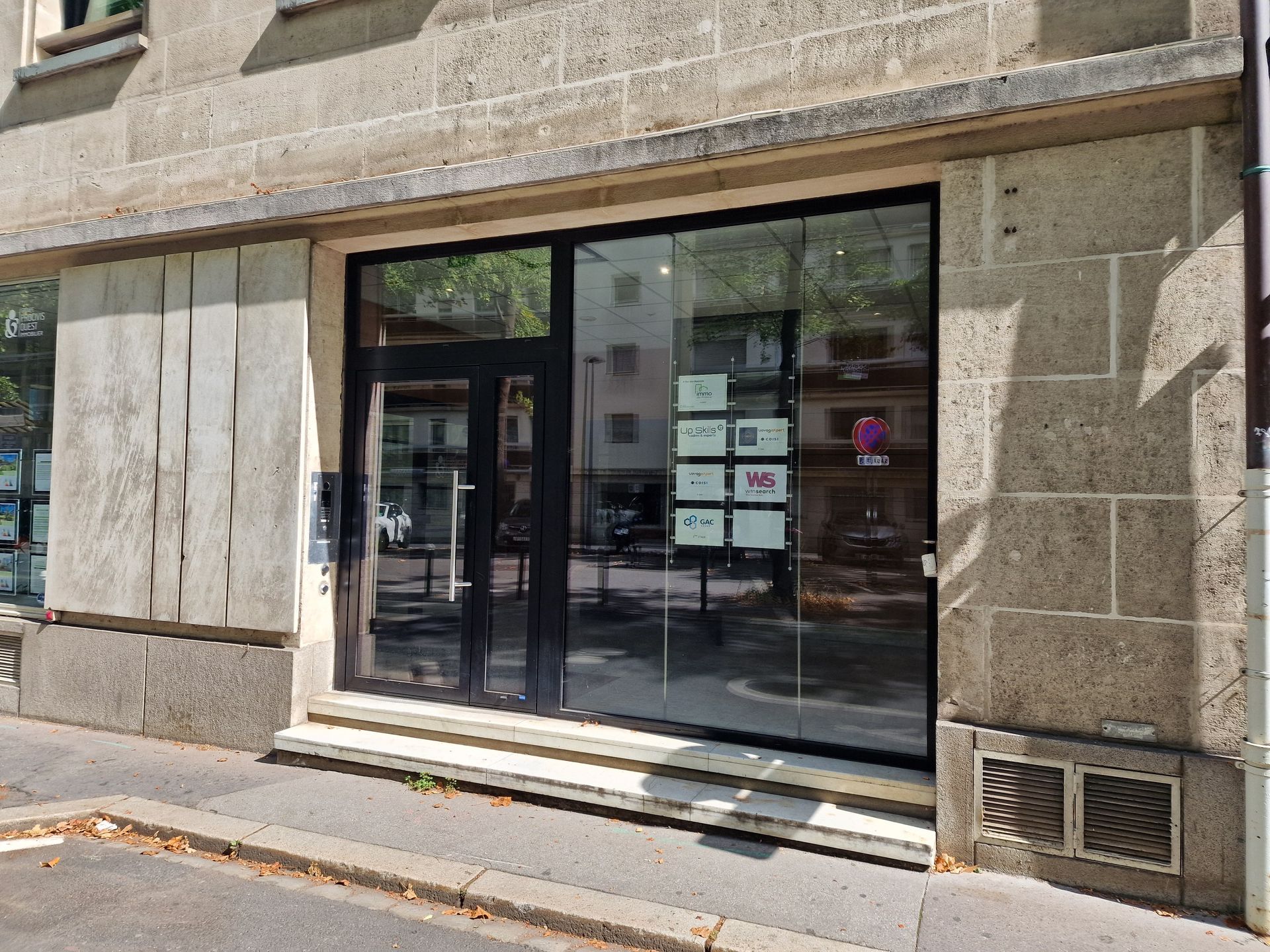 Vue extérieure d'un immeuble commercial avec une porte et une fenêtre vitrées.