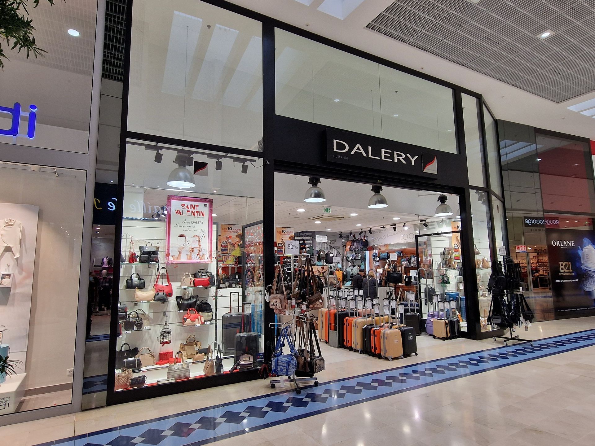 Façade de magasin dans un centre commercial. Vitrines présentant sacs, bagages et accessoires.