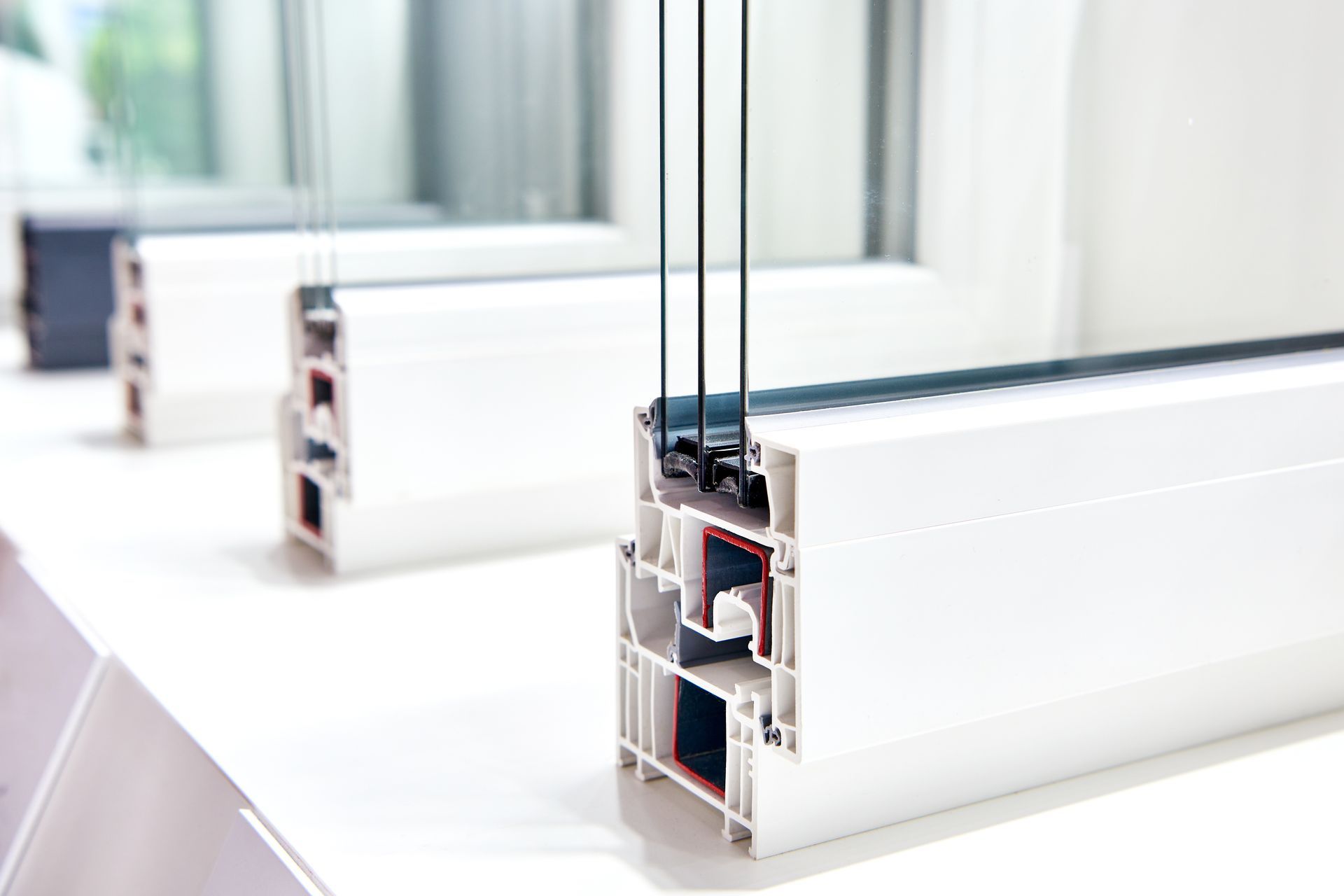 Coupe transversale de cadres de fenêtres blancs, montrant le vitrage multiple et les composants internes.