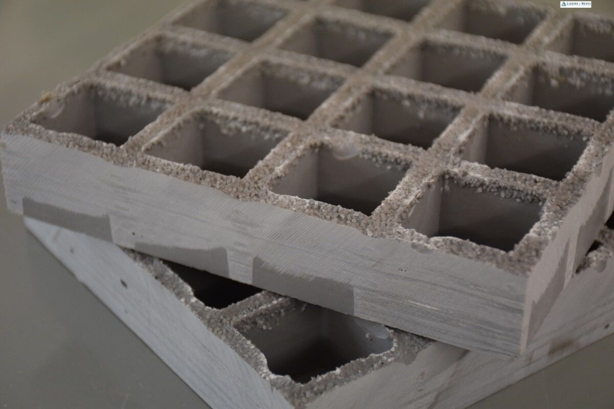 Dois blocos de concreto cinza, com furos quadrados, empilhados.