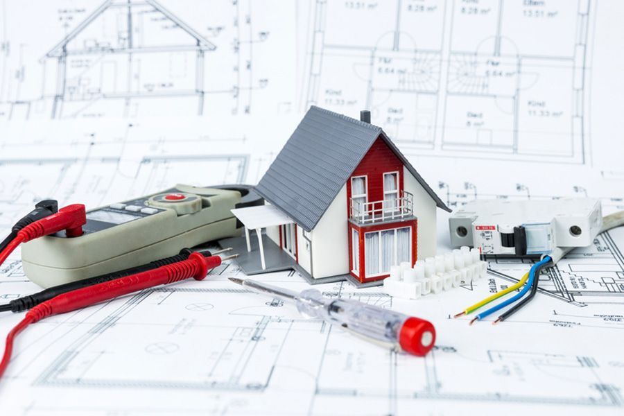 Ein Modellhaus steht auf einem Bauplan