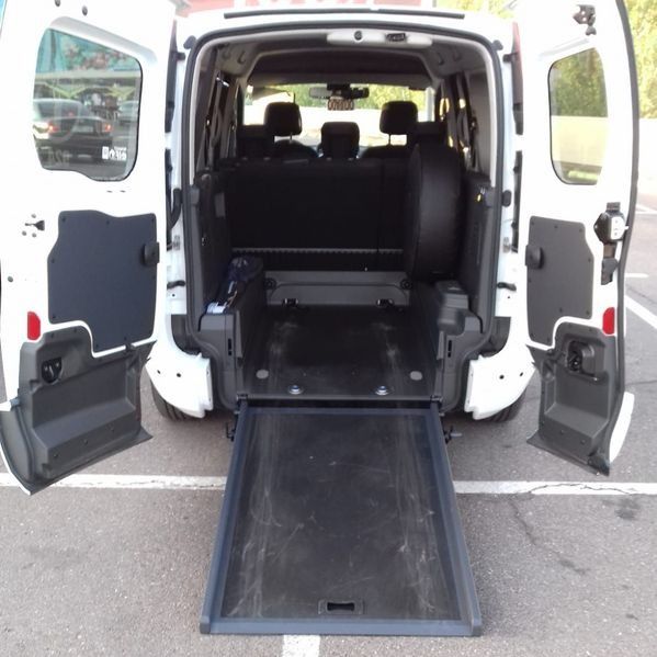 La parte trasera de una furgoneta blanca con las puertas abiertas.