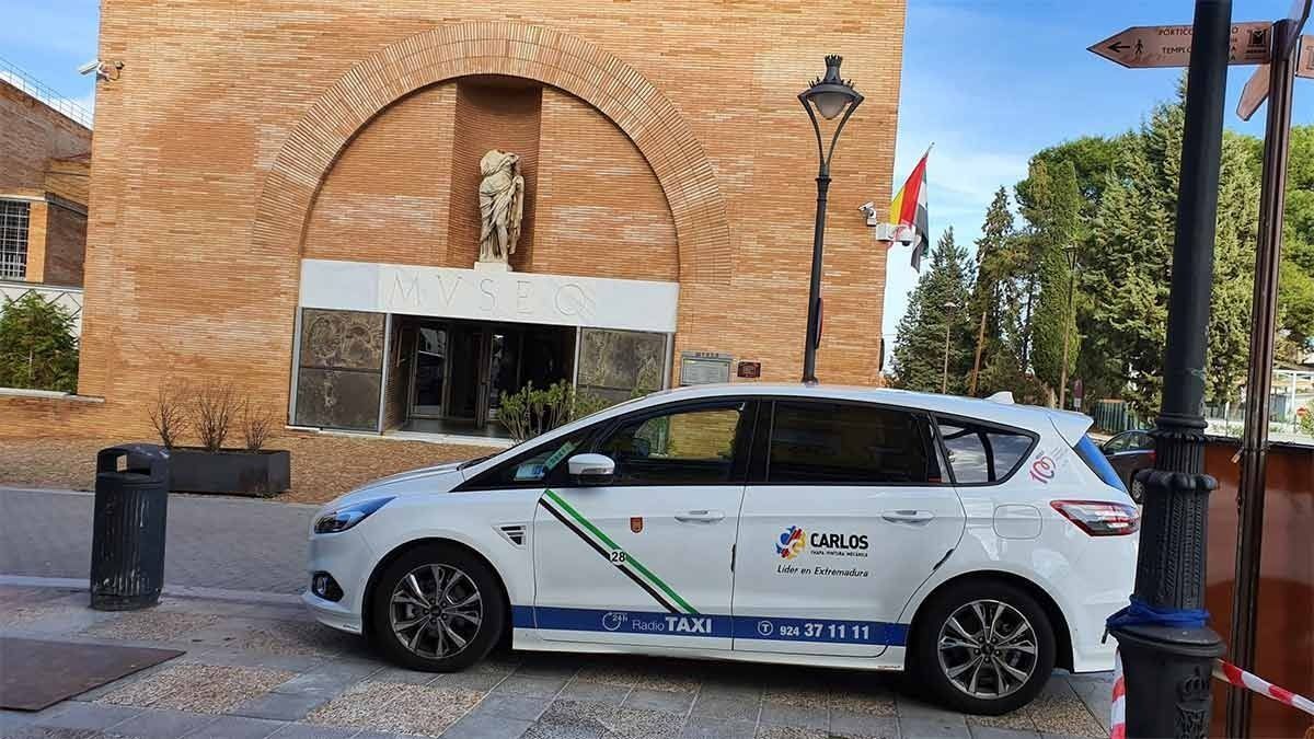 Un coche blanco está aparcado delante de un edificio de ladrillo.