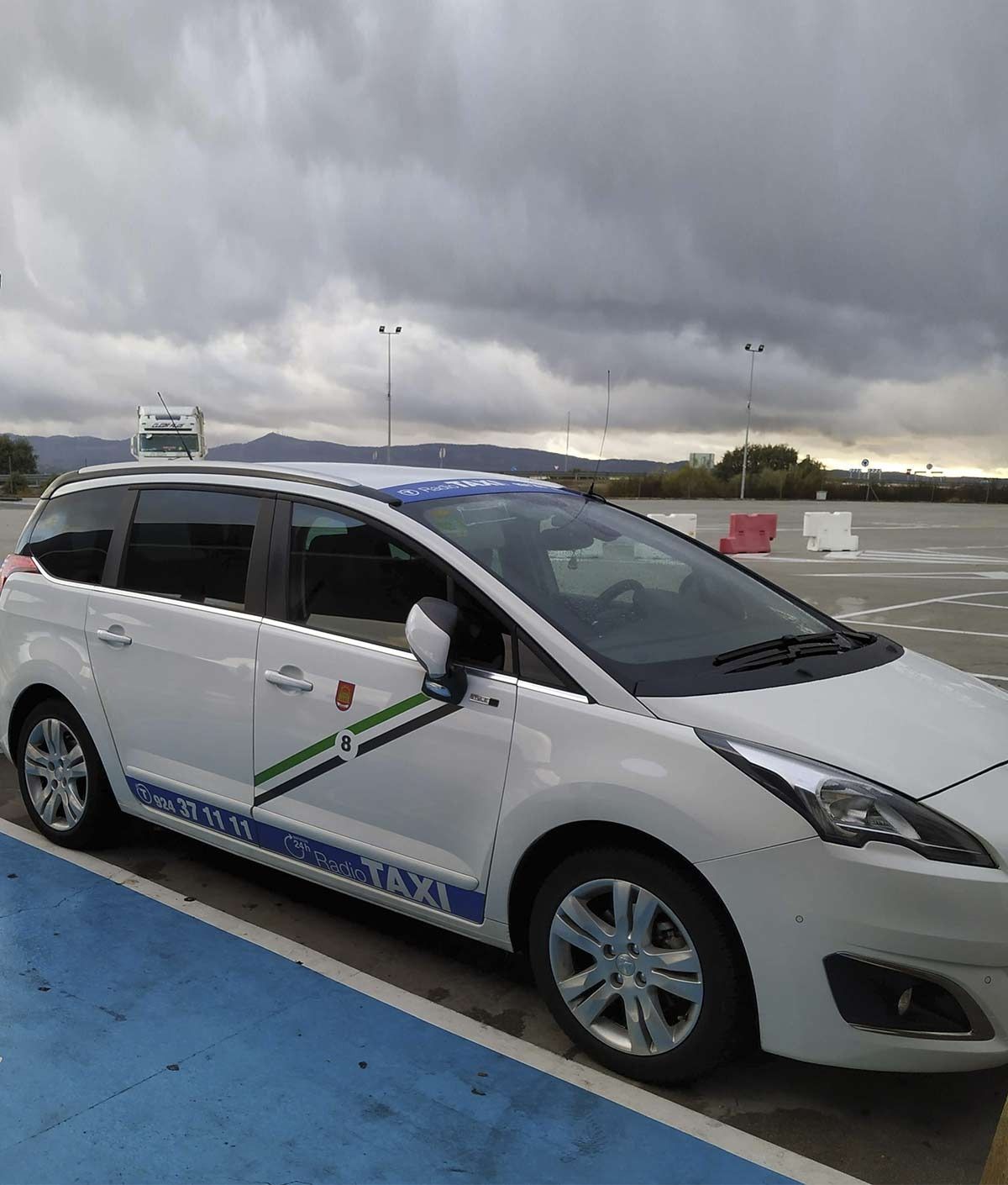 Un coche blanco está estacionado en un estacionamiento en un día nublado.