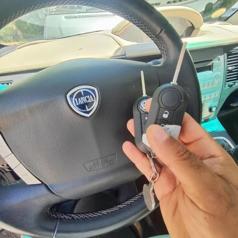 Une paire de clés devant un volant