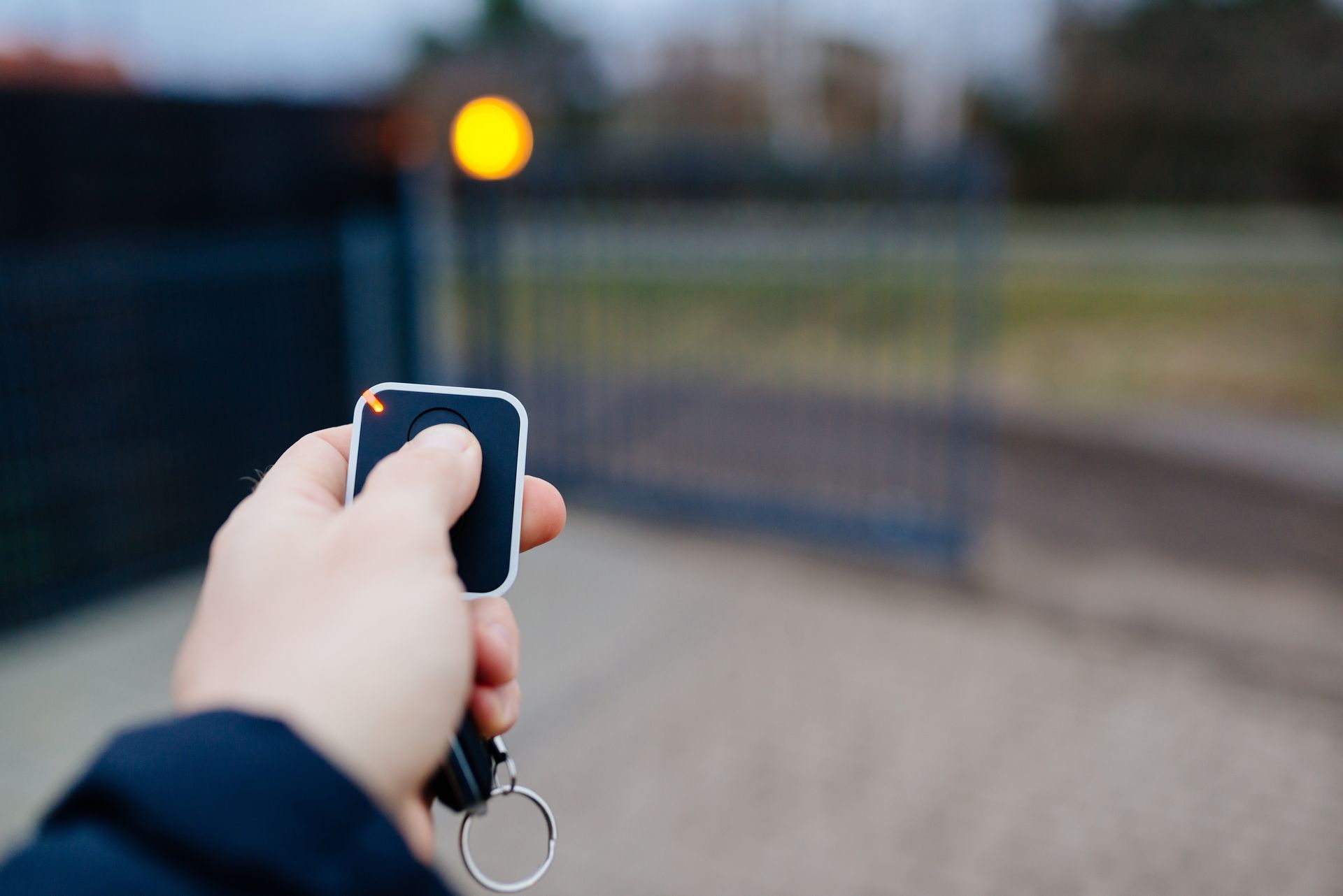 Une personne ouvrant un portail avec une télécommande