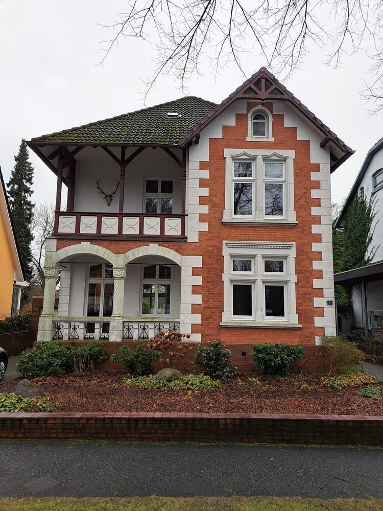 Ein großes Backsteinhaus mit einem davor geparkten Auto
