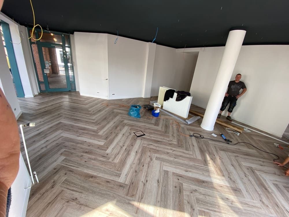 Ein Mann steht in einem Raum mit Fischgrätboden.