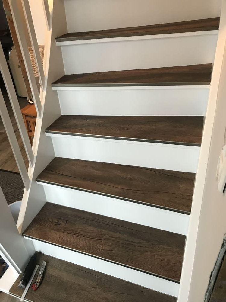 Eine Treppe mit Holzstufen und weißem Geländer.
