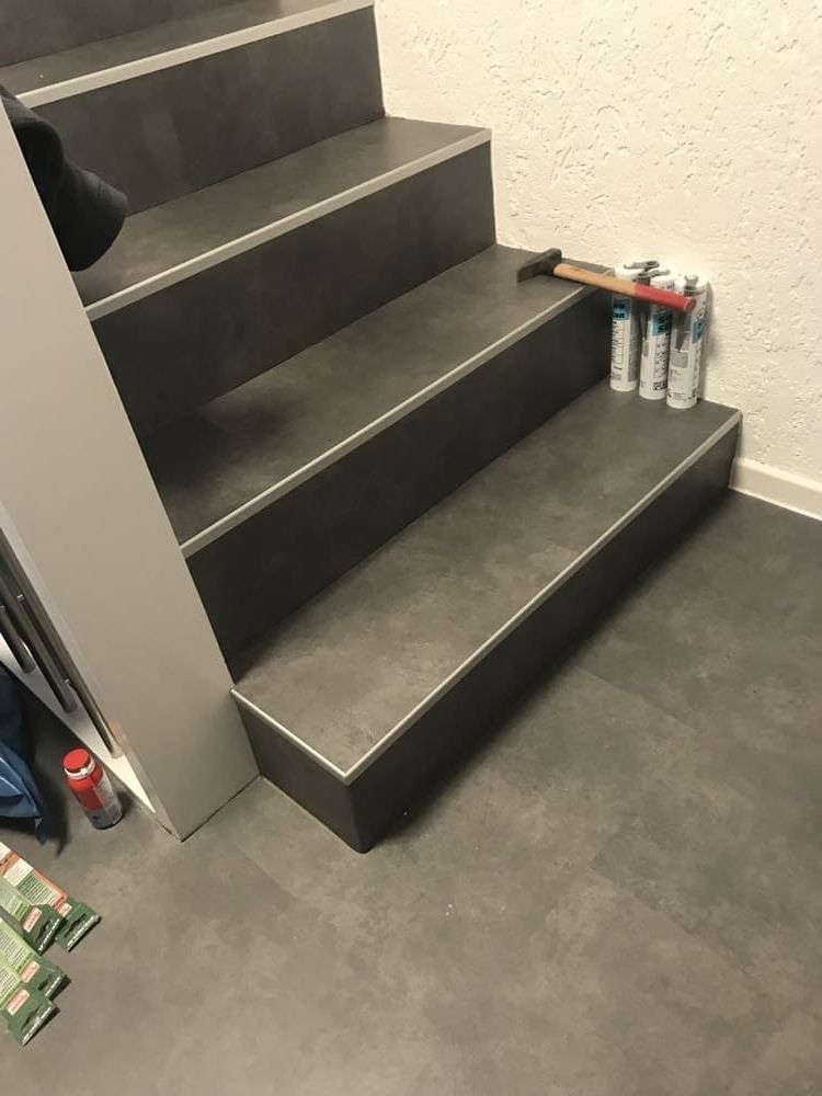 Eine Treppe auf einem gefliesten Boden neben einer Wand.