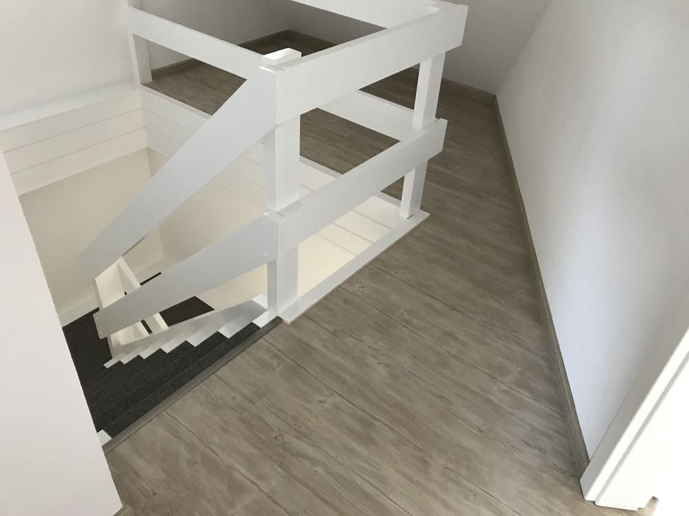 Eine Treppe mit weißem Geländer und Holzboden
