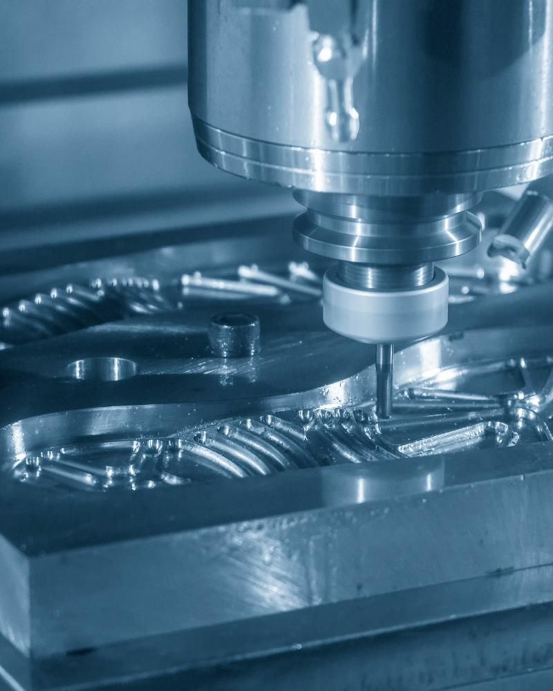 Una máquina está cortando un trozo de metal en una máquina.