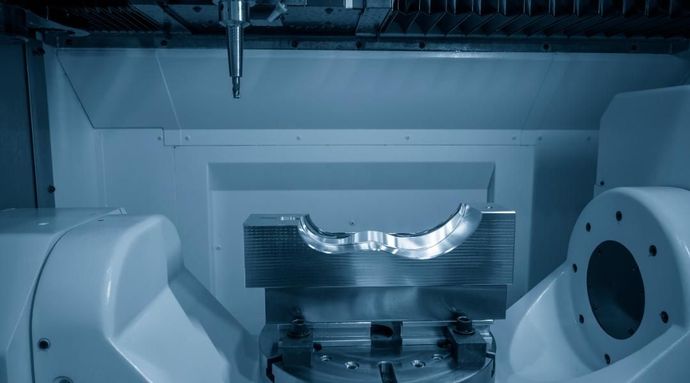 Una máquina está cortando un trozo de metal en una fábrica.