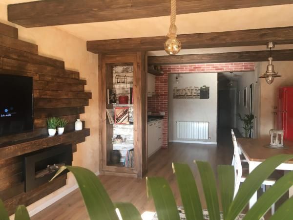 Una sala de estar con chimenea y TV de pantalla plana.