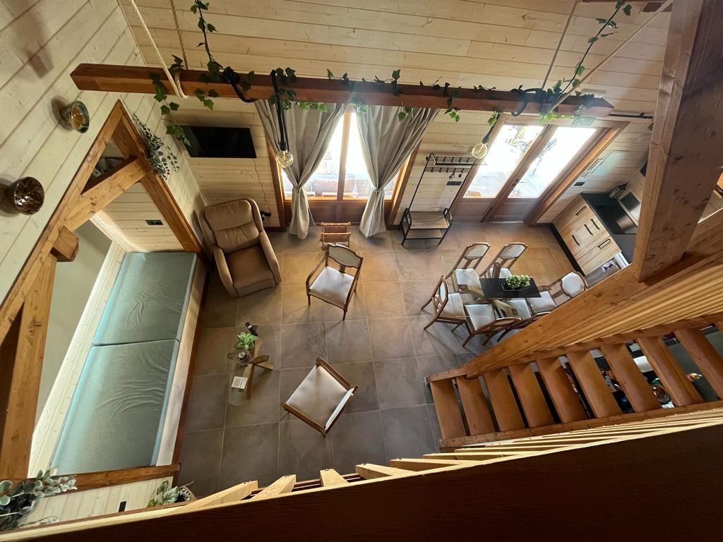 Una vista aérea de una sala de estar con escaleras que conducen al segundo piso.