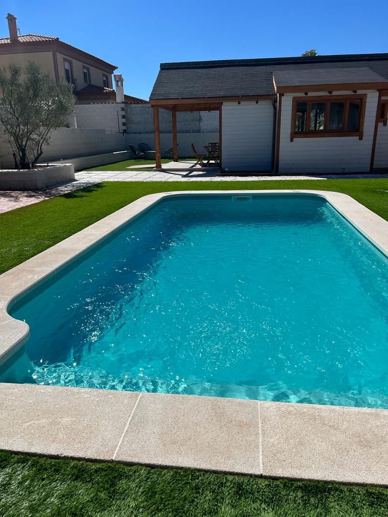 Una gran piscina en el patio trasero de una casa