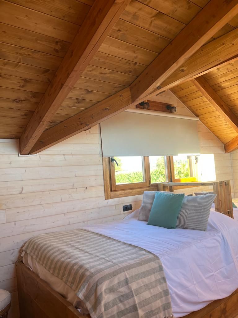 Un dormitorio con una cama y un techo de madera.