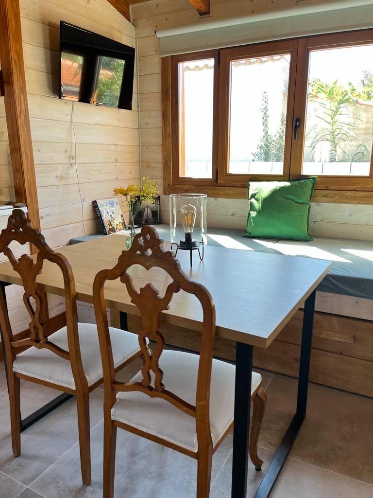 Un comedor con una mesa y sillas frente a una ventana.