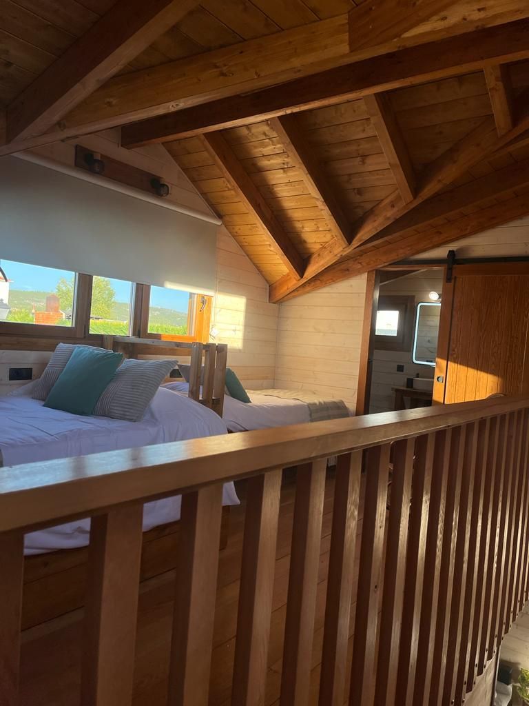 Un dormitorio con barandilla de madera y una cama.