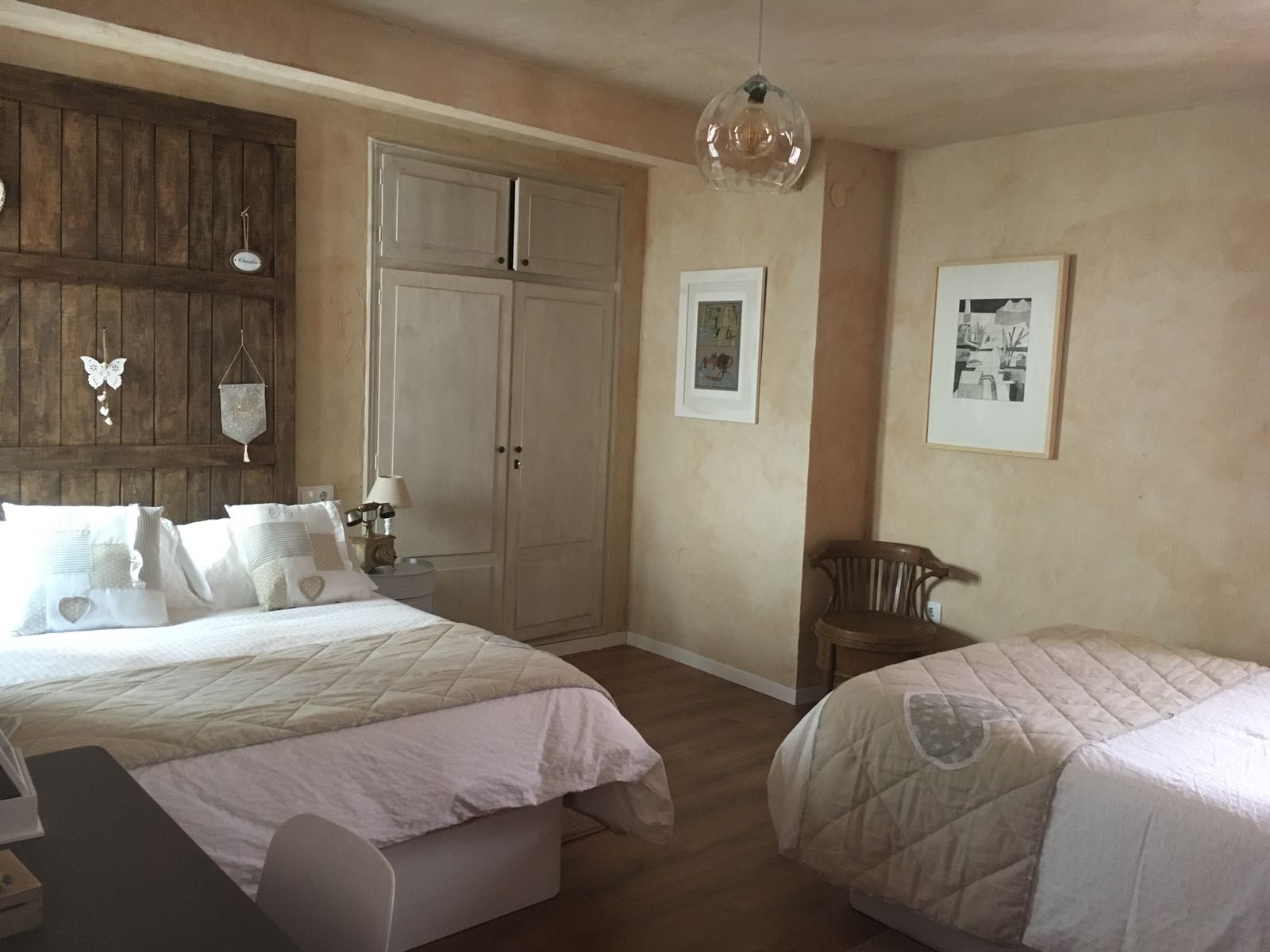 Un dormitorio con dos camas y una silla.