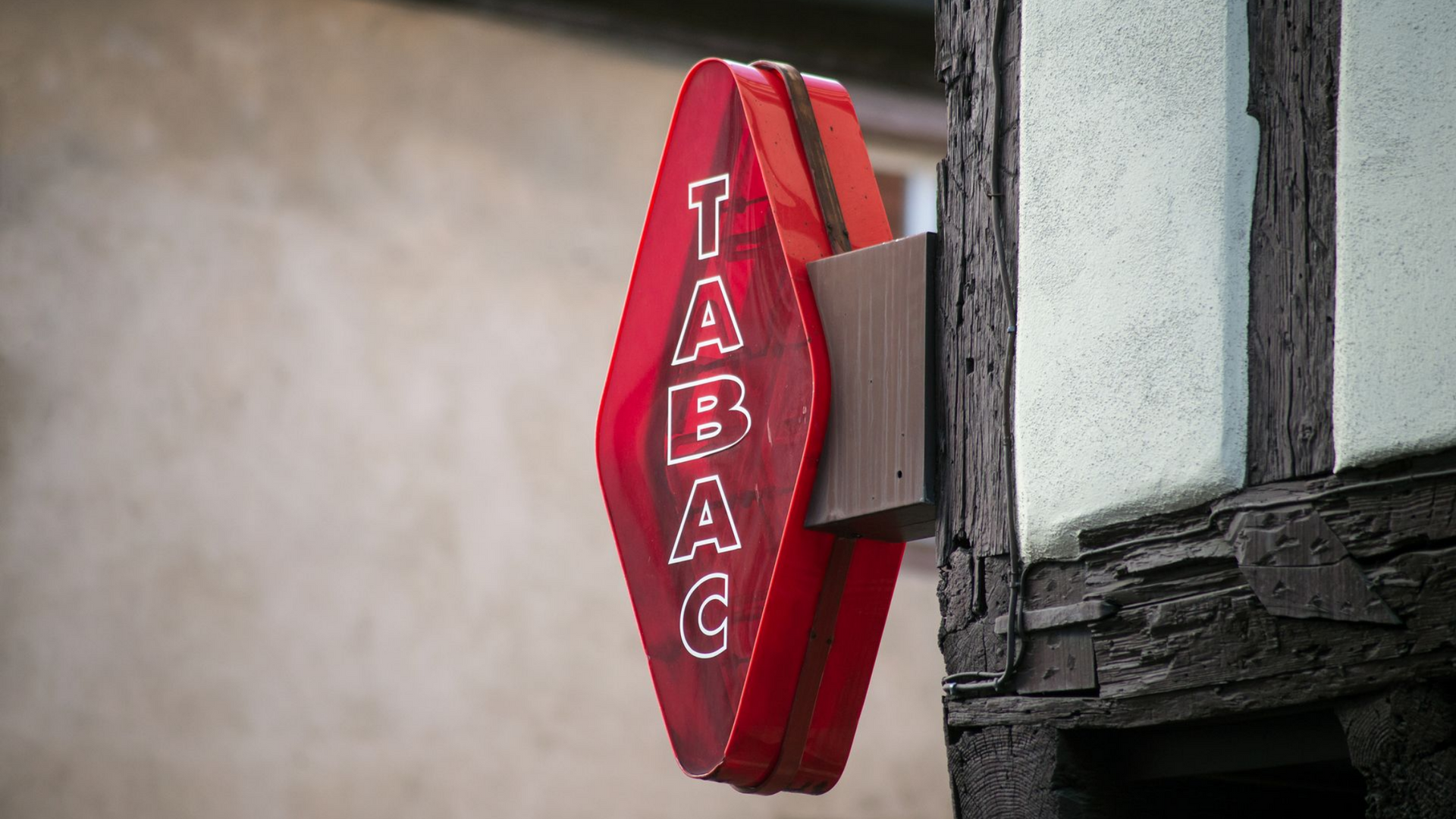 Panneau rouge TABAC à l'angle d'un bâtiment.