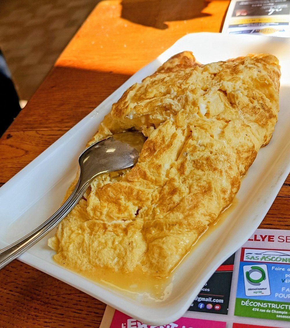Gros plan sur des œufs brouillés dorés sur une assiette blanche.