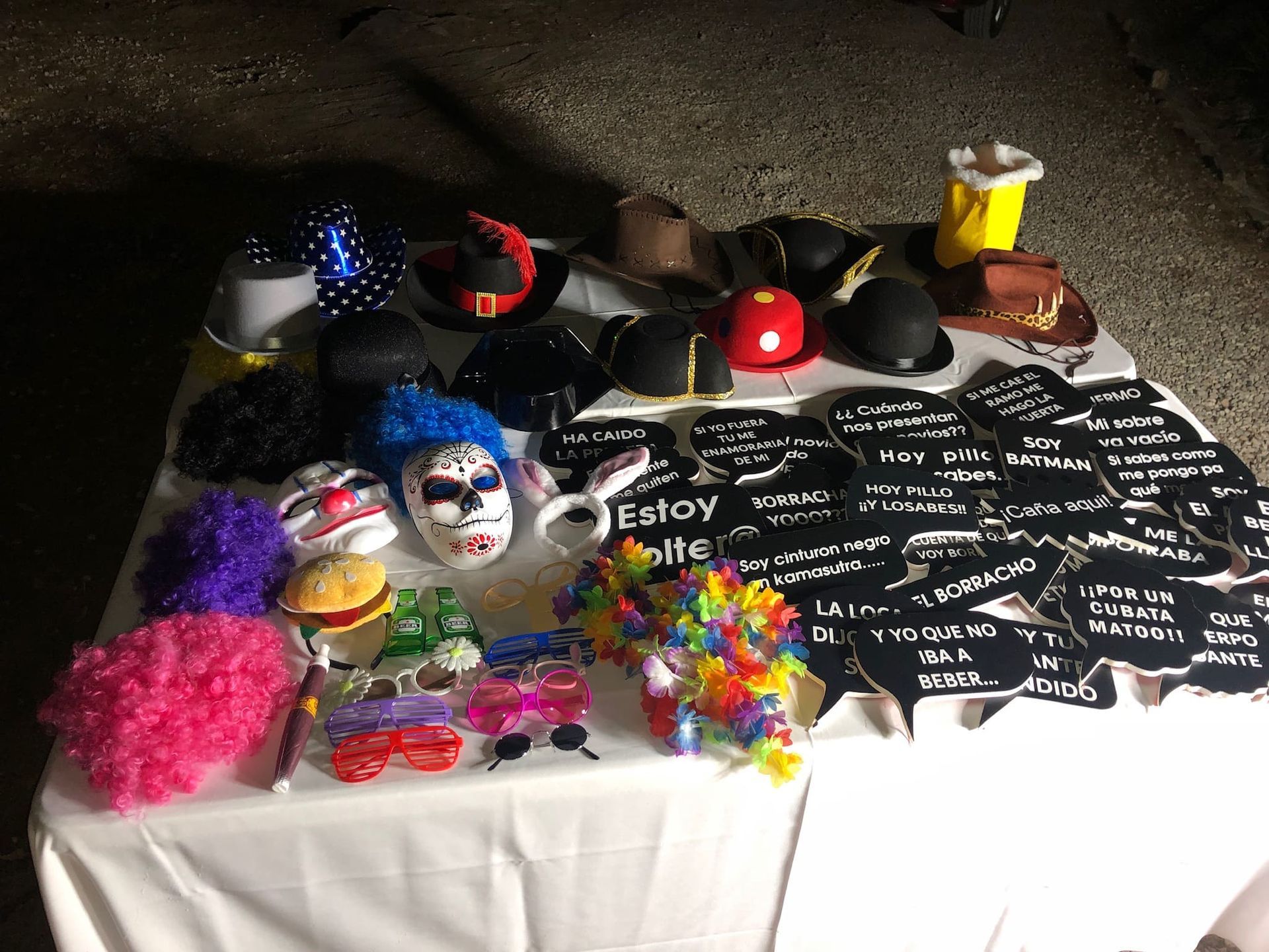 Una mesa con un montón de máscaras y sombreros de payaso sobre ella.