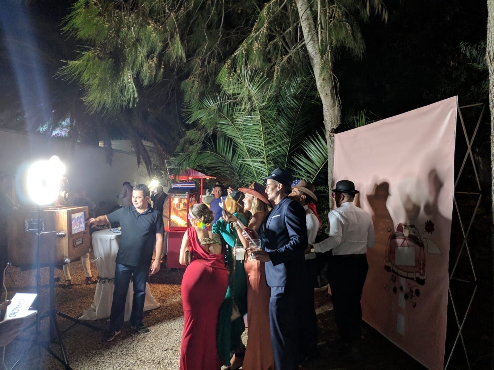 Un grupo de personas se encuentra frente a un fotomatón por la noche.