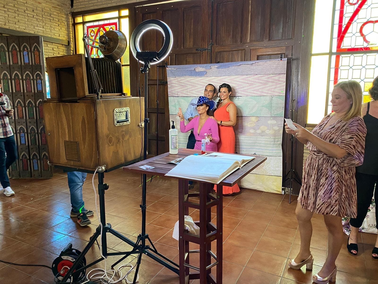 Una mujer está tomando una fotografía de dos mujeres frente a un fotomatón.
