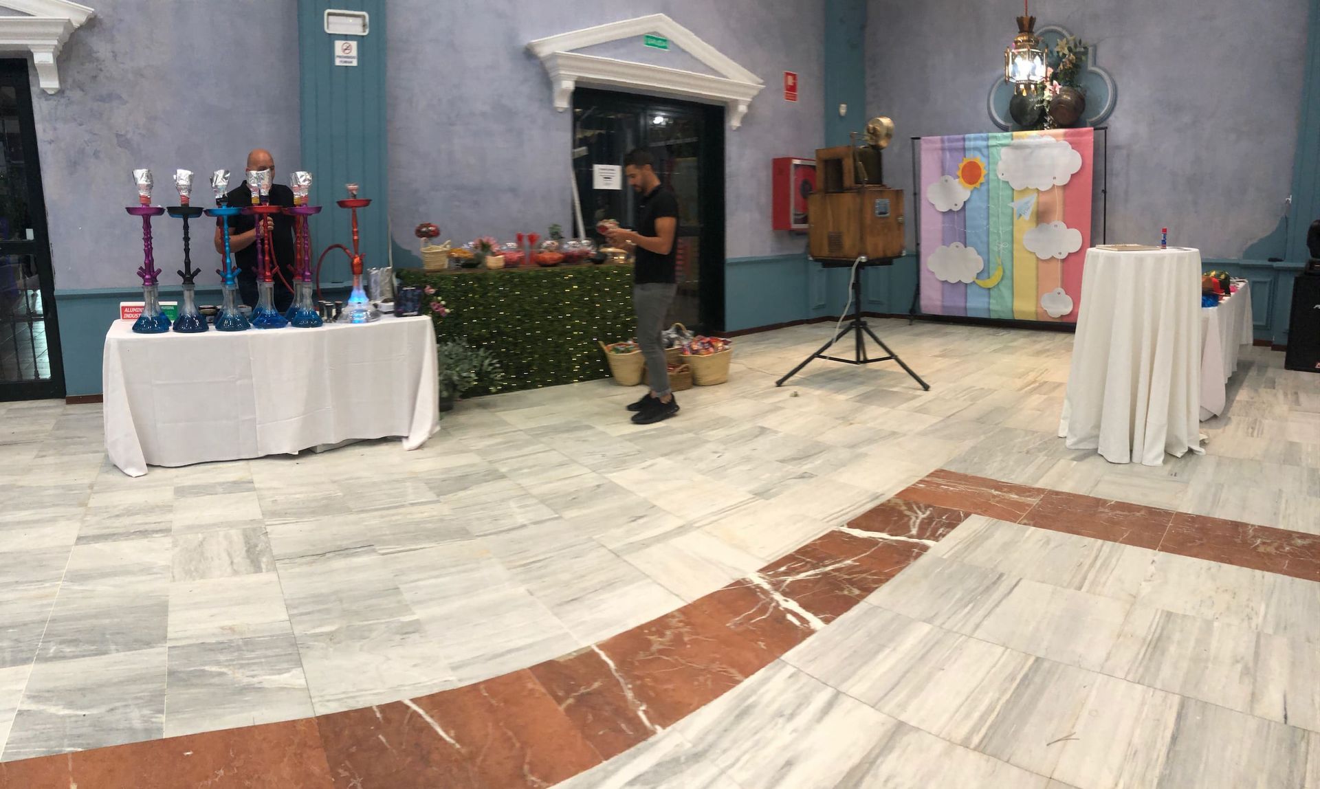 Un hombre está de pie en una habitación con mesas y velas.