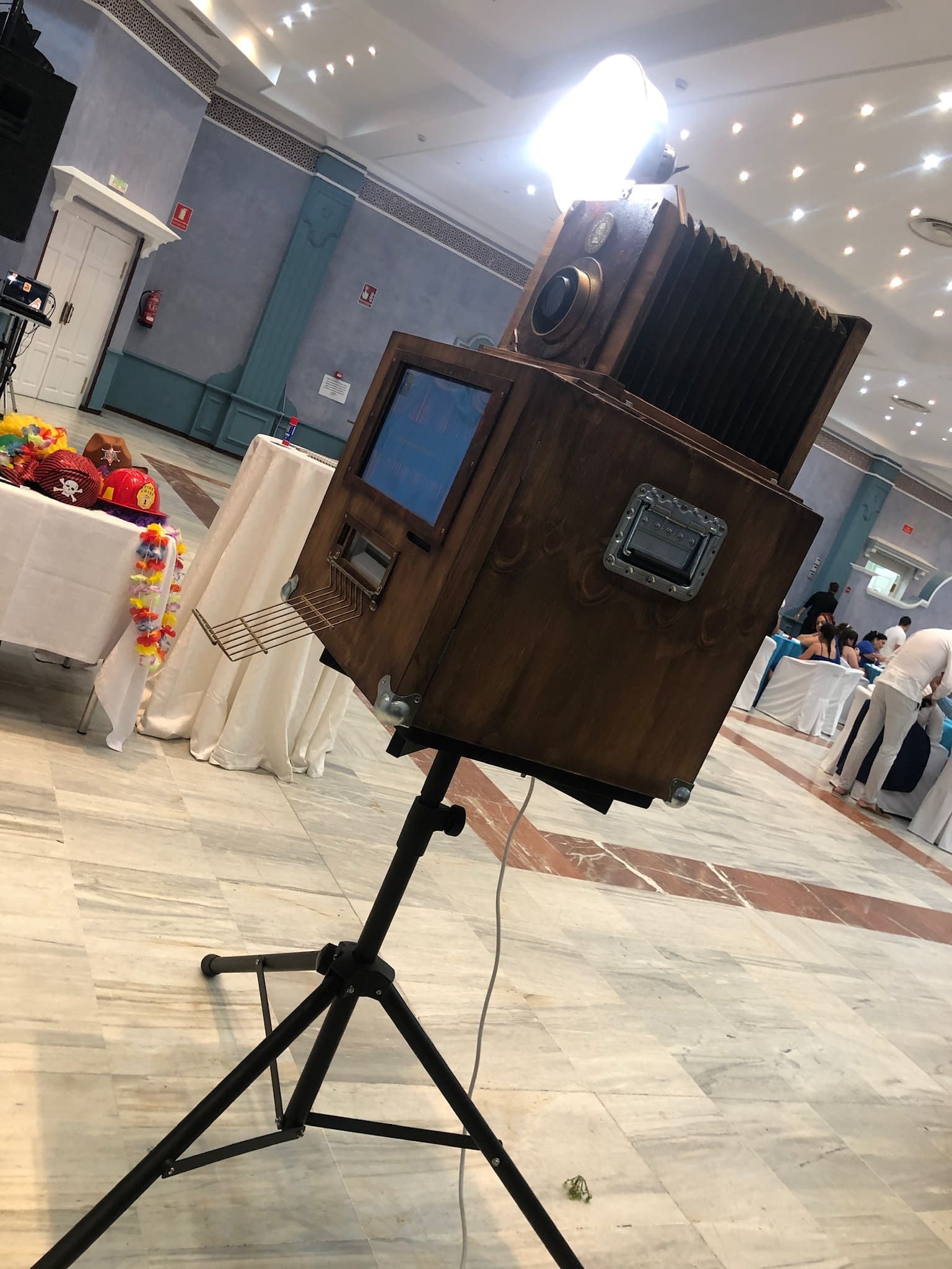 Una caja de madera está colocada sobre un trípode en una habitación.