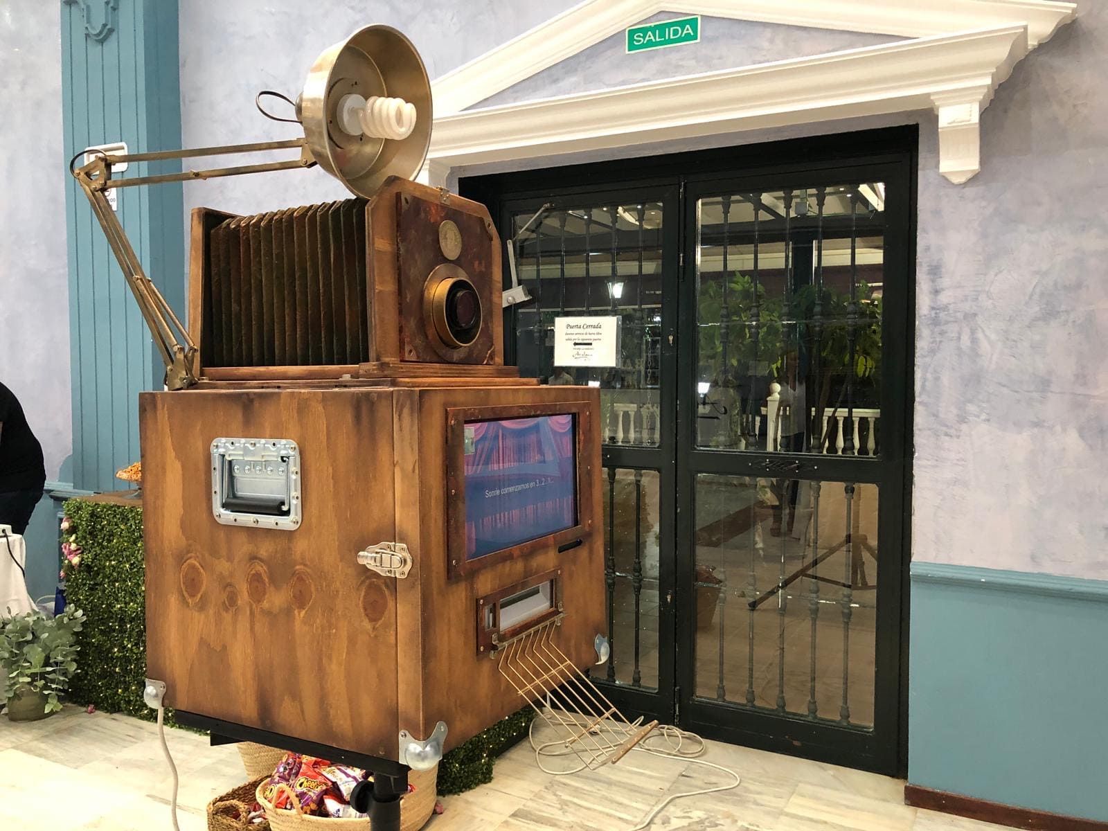Una gran cámara de madera está situada delante de un edificio.