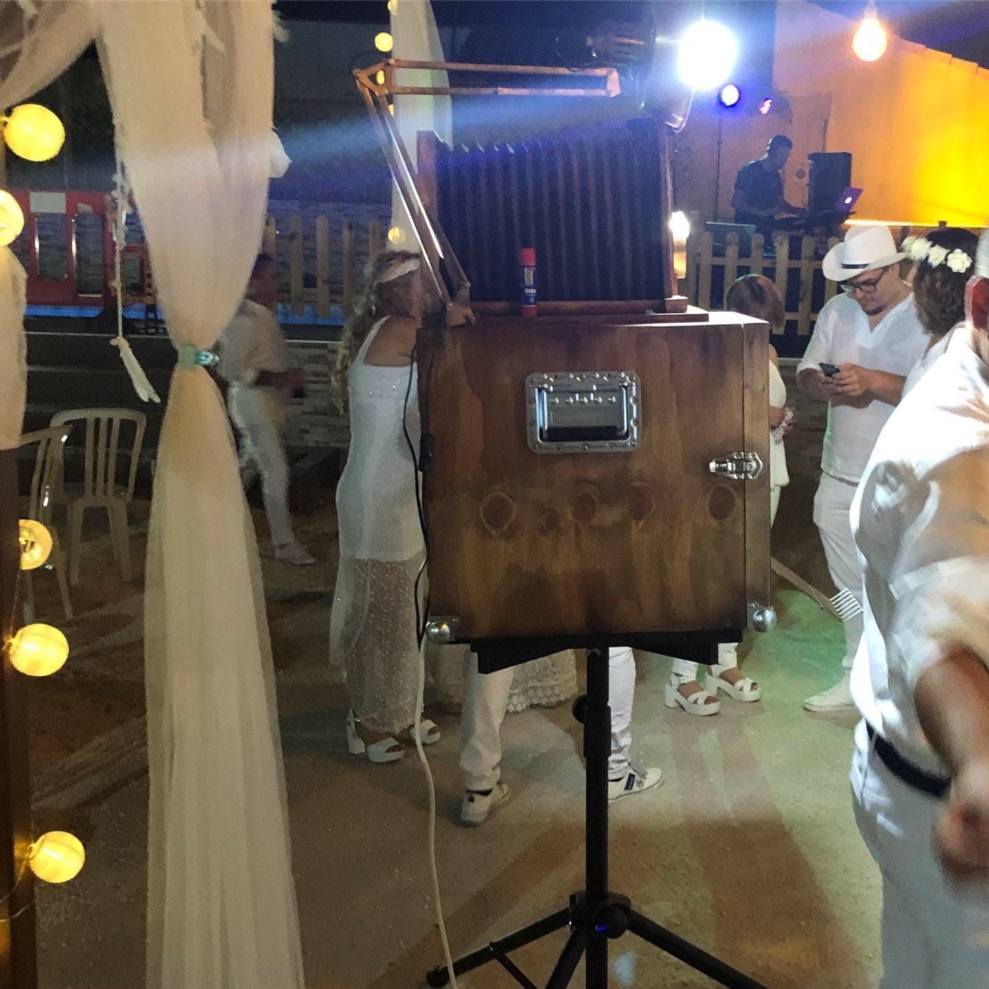 Un grupo de personas están de pie alrededor de una caja de madera con un asa.