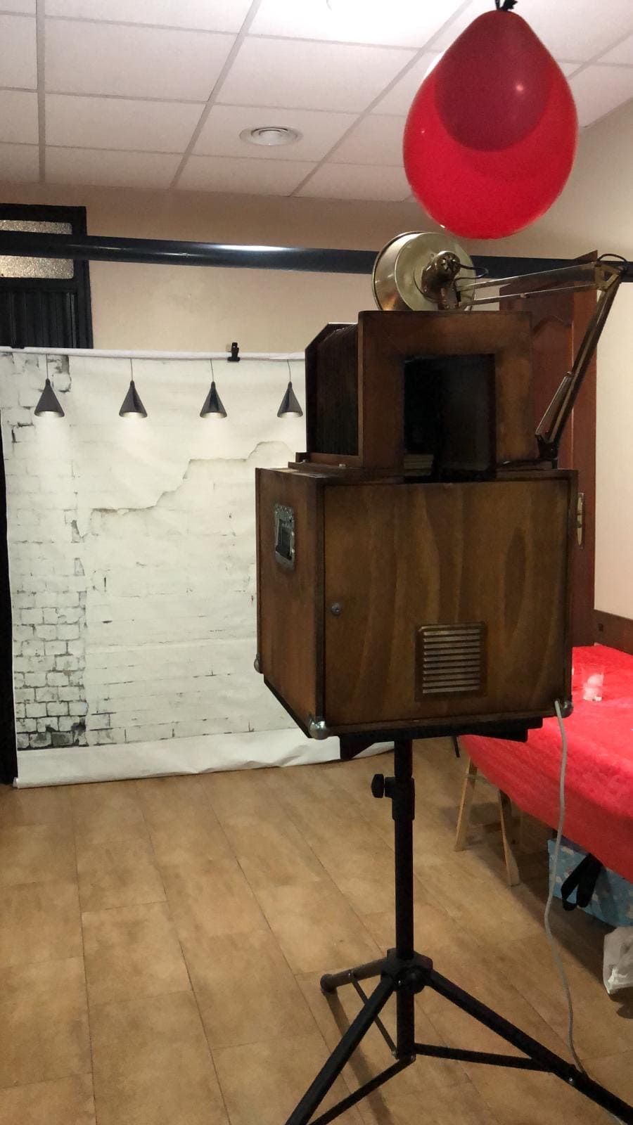 Un globo rojo cuelga de una caja de madera en una habitación.