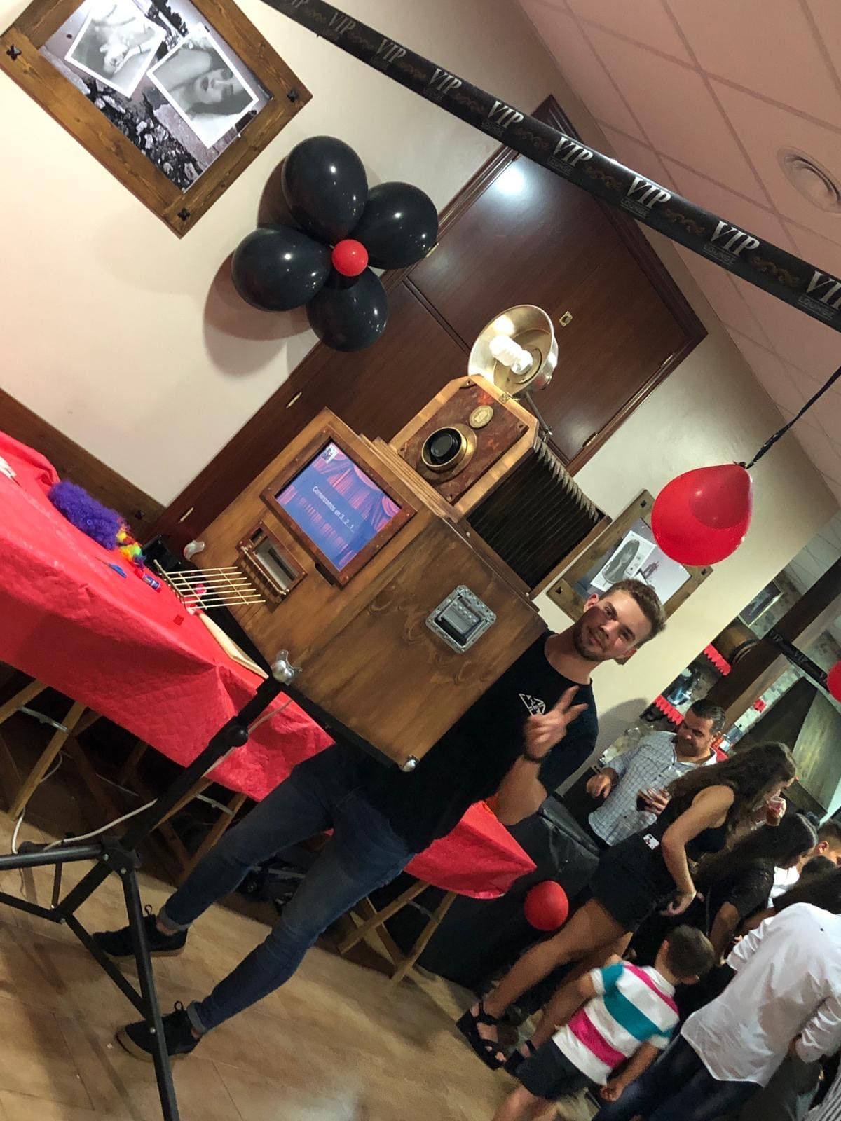 Un hombre está parado frente a un fotomatón en una fiesta.