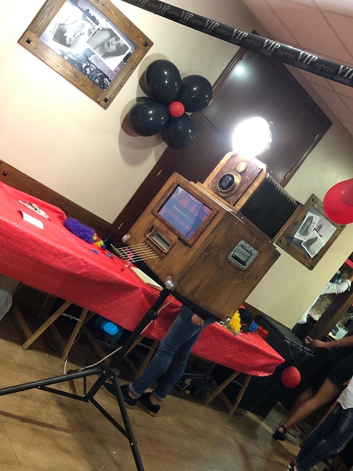 Un fotomatón con globos y fotos en la pared.