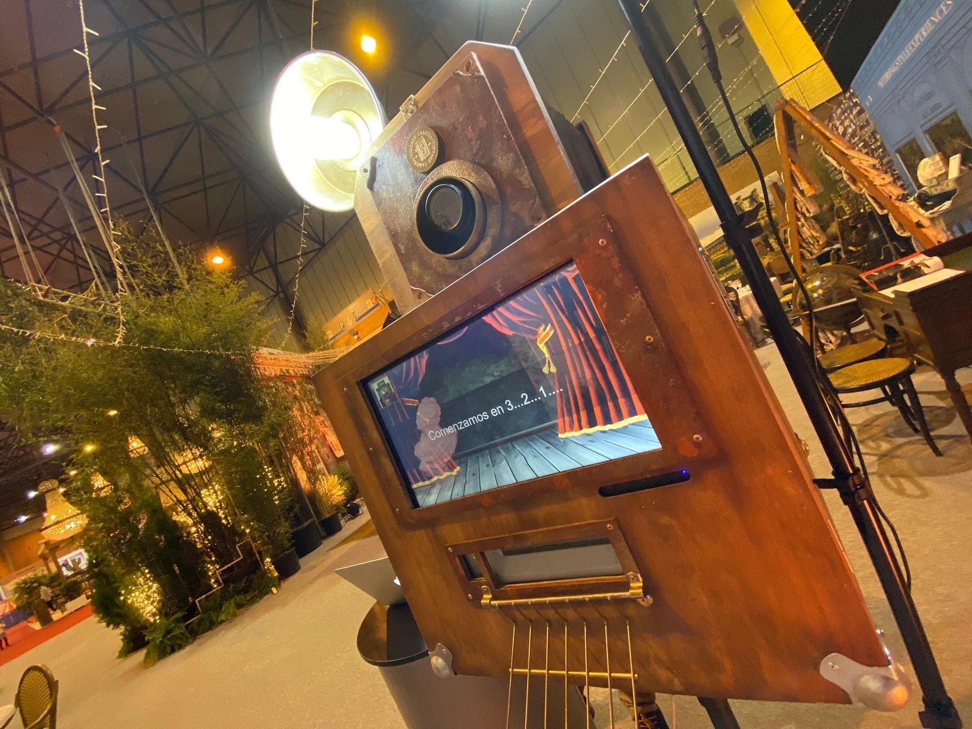 Un fotomatón de madera con una cámara y una pantalla.